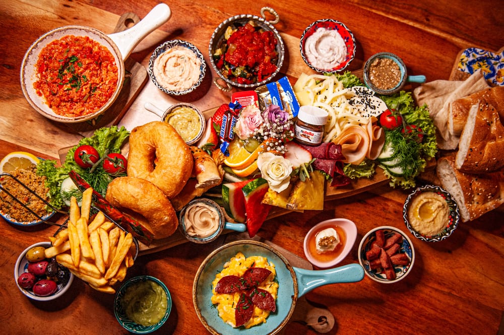 Türkischer Frühstückstisch von oben mit Käse, Oliven, Eierspeisen und Gebäck